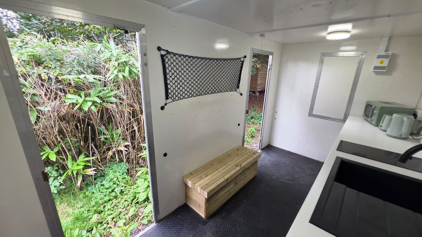 Looking back at the entrance, with a wooden bench by the door.